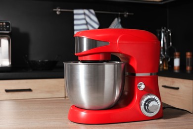 Photo of Modern stand mixer on wooden table in kitchen