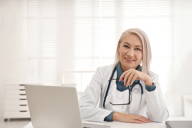 Photo of Portrait of mature female doctor in white coat at workplace