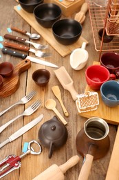 Photo of Many different cooking utensils on wooden table, above view. Garage sale