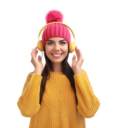 Young woman listening to music with headphones on white background