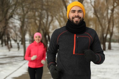 Happy people running in winter park. Outdoors sports exercises