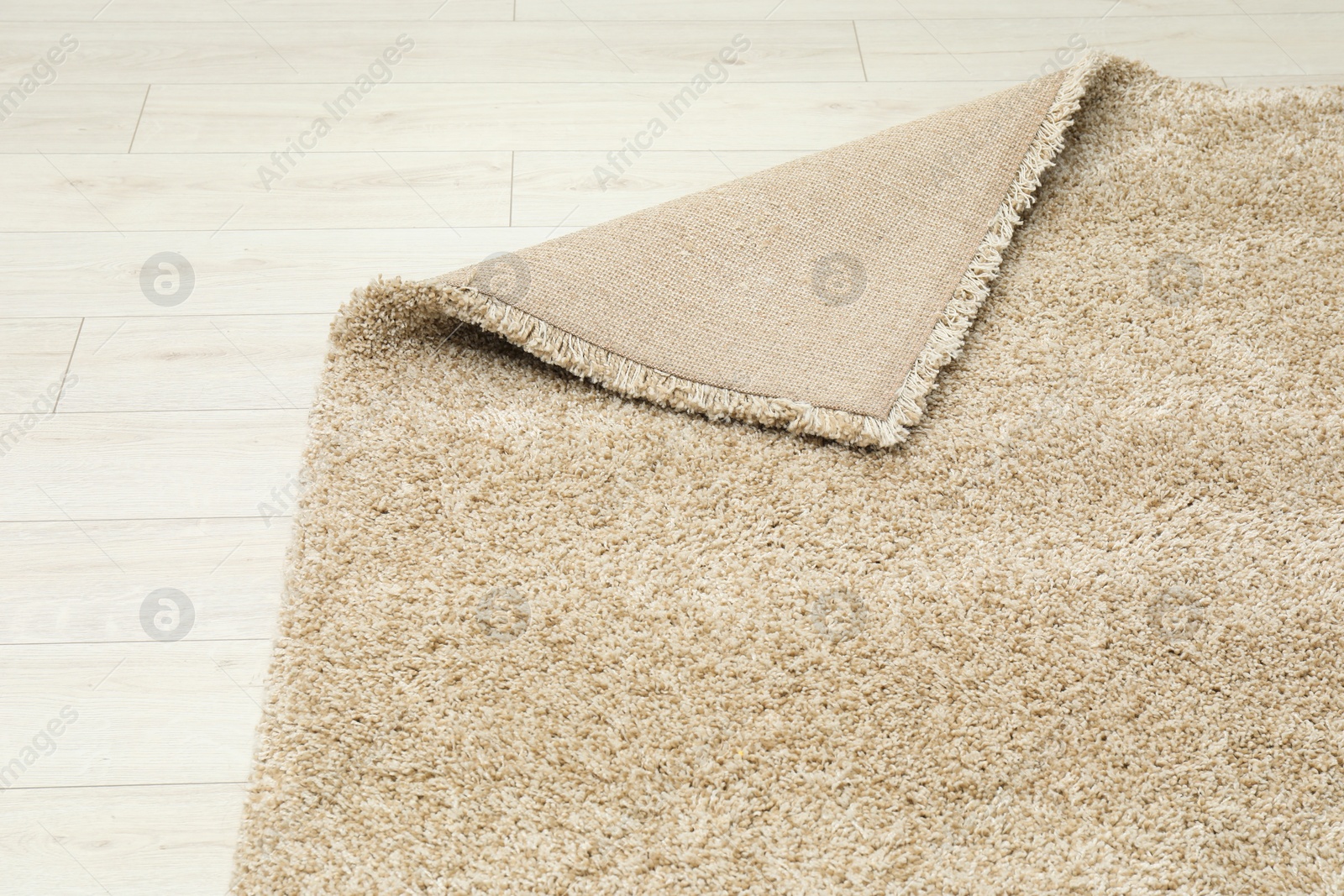 Photo of Soft beige carpet on white laminated floor indoors