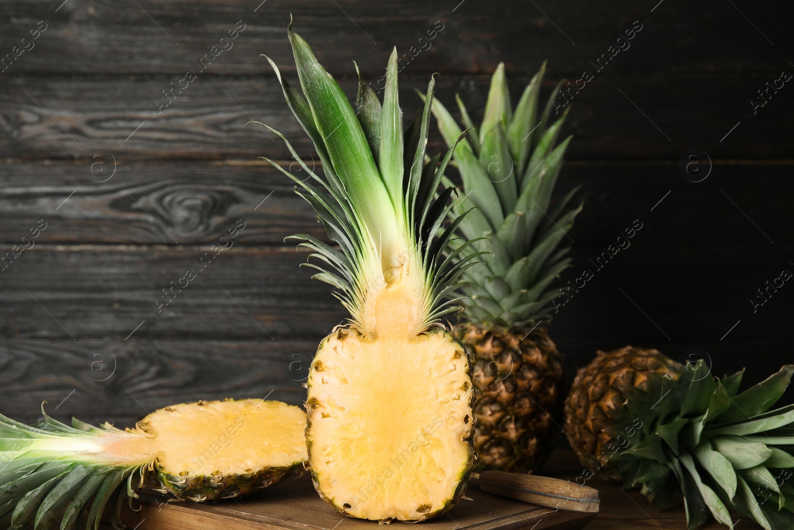 Photo of Cut fresh juicy pineapple on wooden board