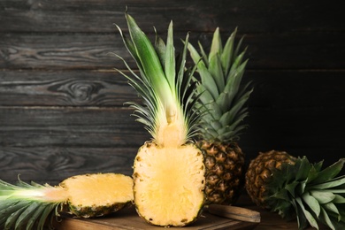 Photo of Cut fresh juicy pineapple on wooden board