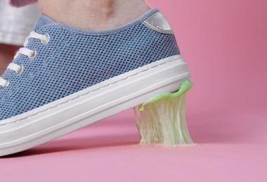 Photo of Person stepping into chewing gum on pink background, closeup