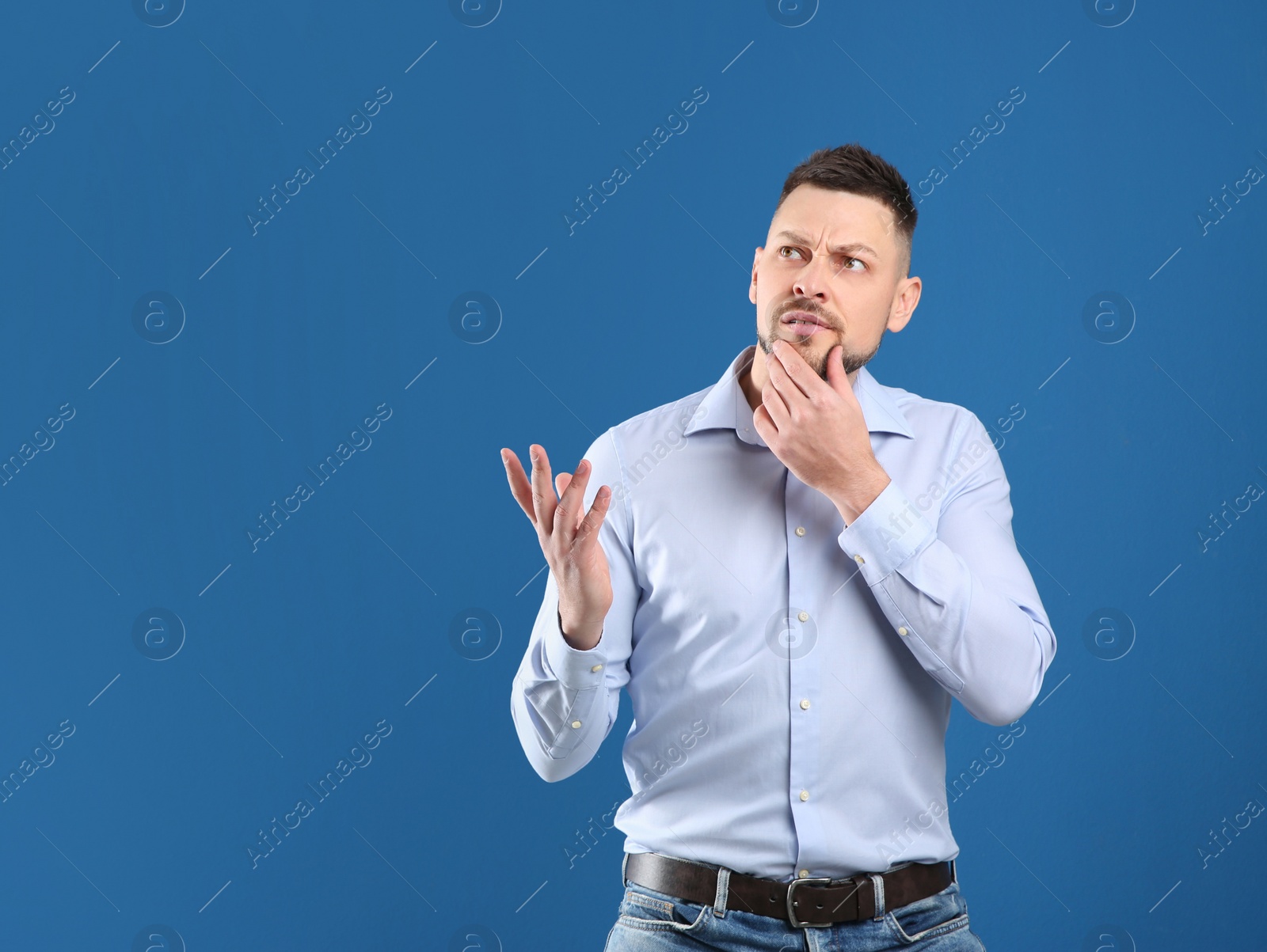 Photo of Thoughtful man on blue background, space for text