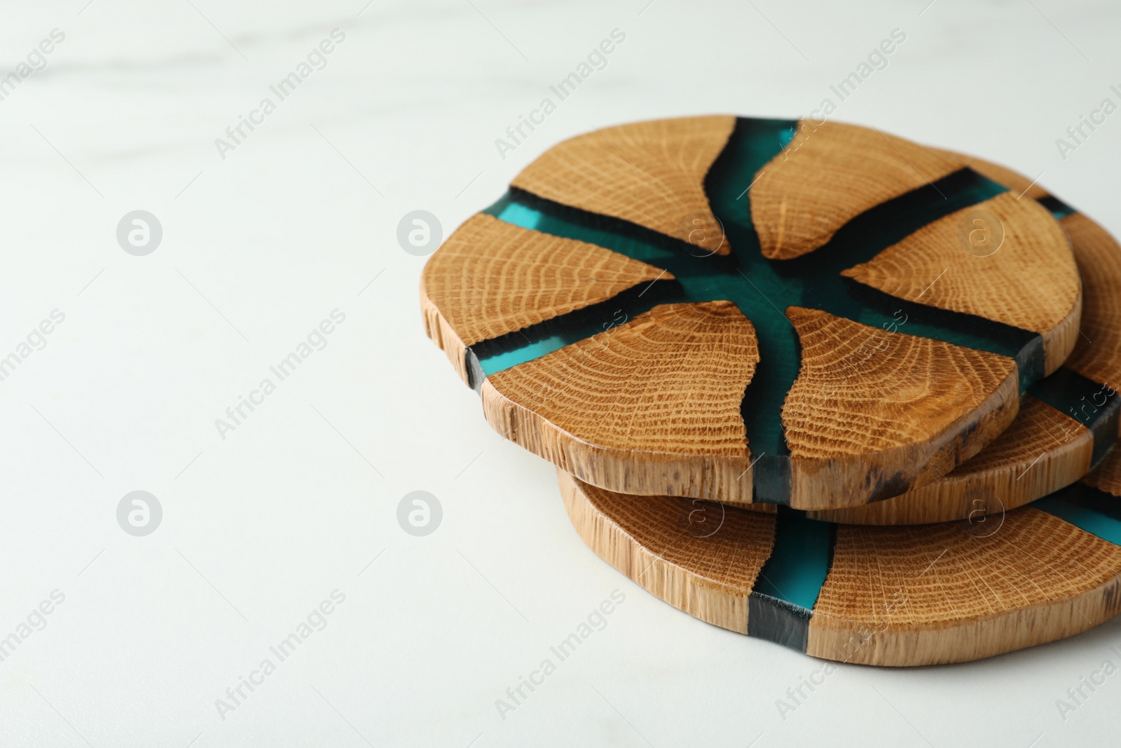 Photo of Stylish wooden cup coasters on white marble table, space for text