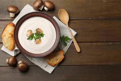 Photo of Fresh homemade mushroom soup served on wooden table, flat lay. Space for text