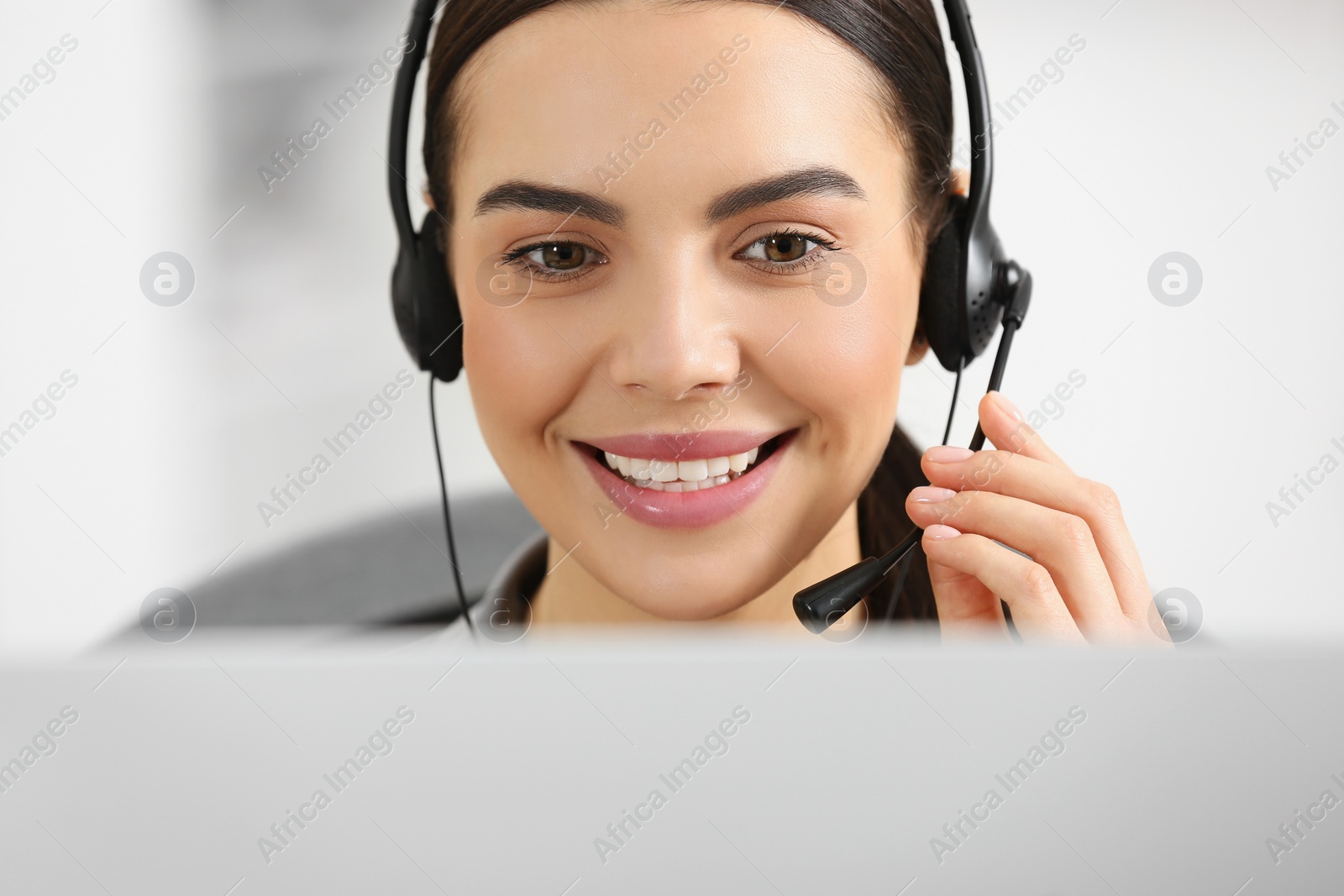 Photo of Hotline operator with headset working on computer in office