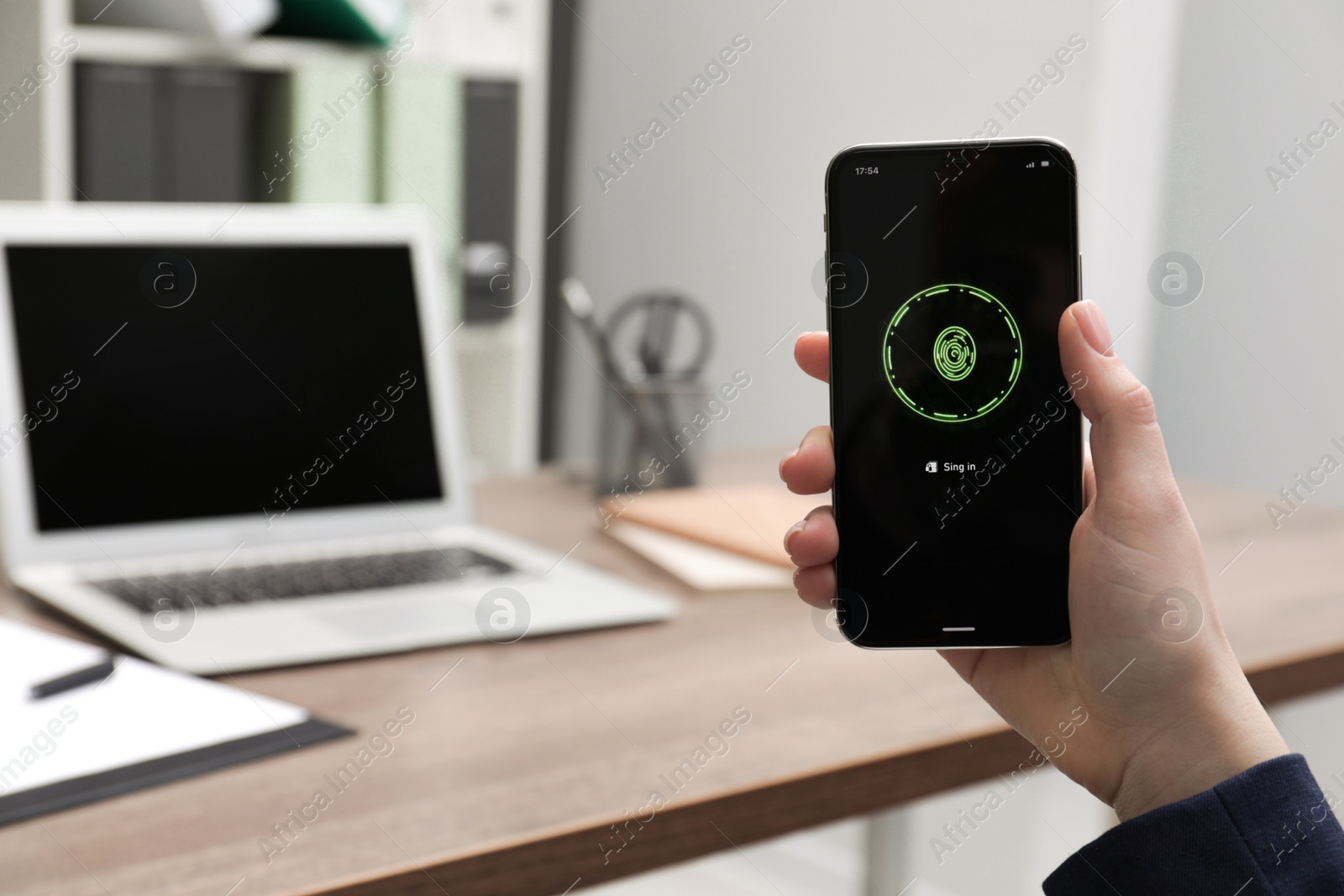 Photo of Woman holding smartphone with fingerprint scanner at workplace, closeup. Space for text