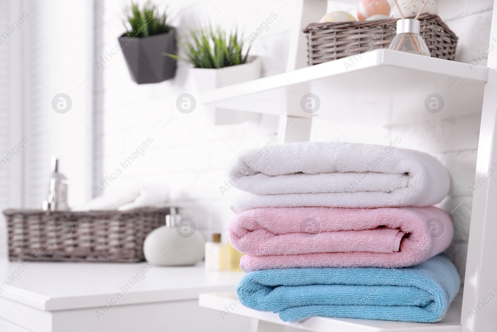 Photo of Stack of fresh towels on shelf in bathroom. Space for text