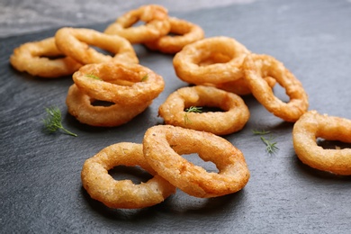 Photo of Delicious fried onion rings on table, closeup