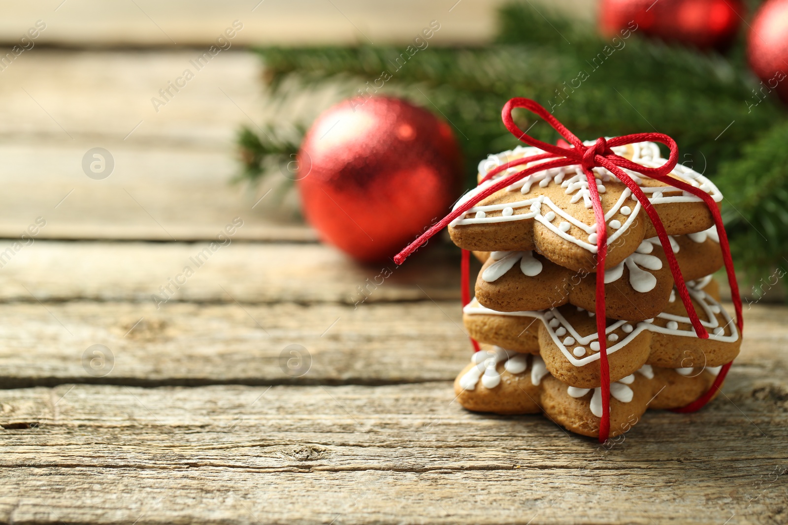 Photo of Tasty Christmas cookies with icing on wooden table. Space for text