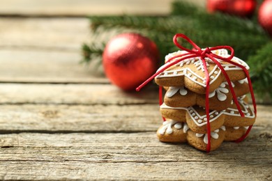 Photo of Tasty Christmas cookies with icing on wooden table. Space for text