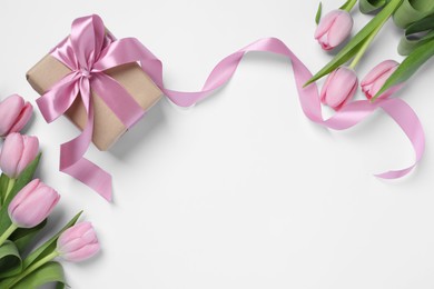 Photo of Beautiful gift box and pink tulip flowers on white background, flat lay. Space for text