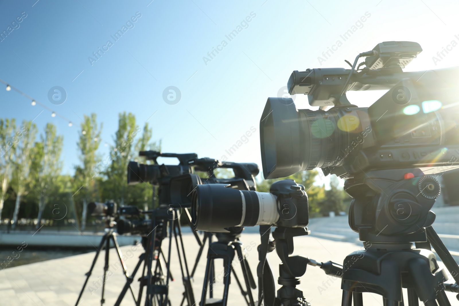 Photo of Modern professional video cameras outdoors on sunny day