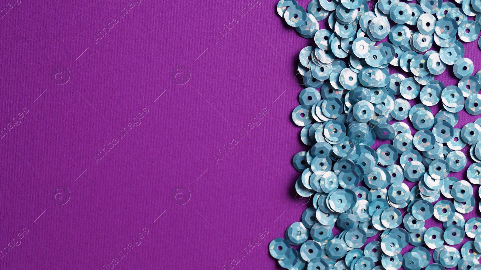 Photo of Many silver sequins on purple background, flat lay. Space for text