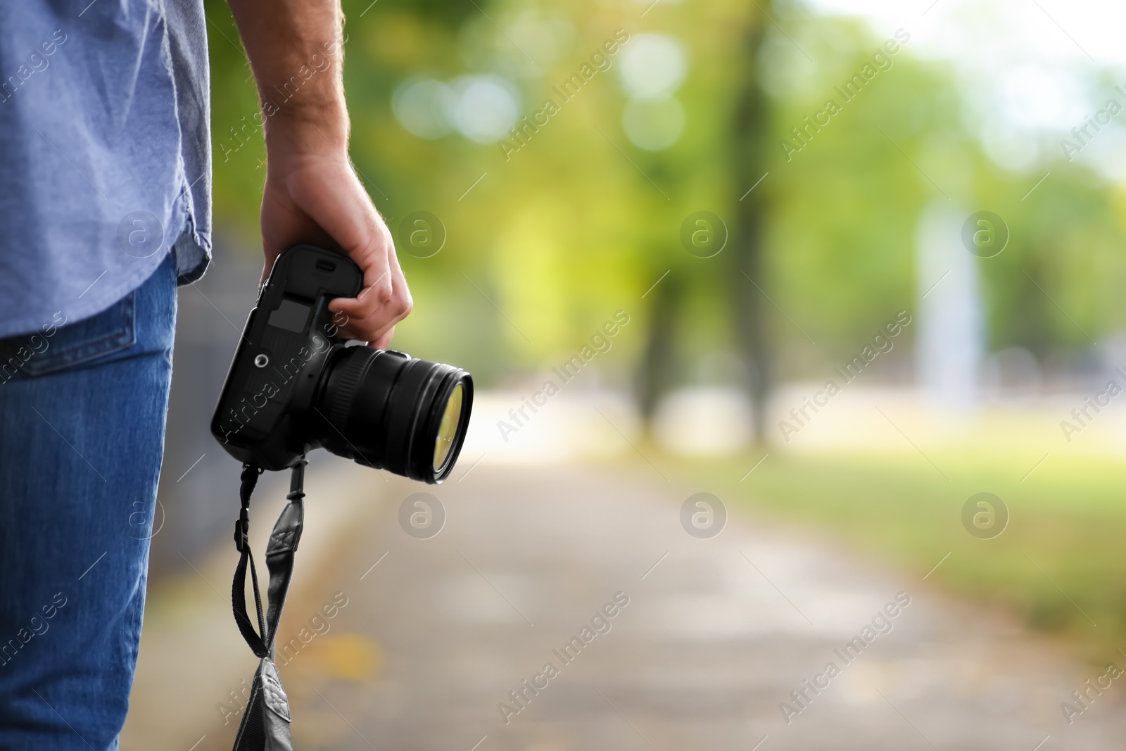 Photo of Photographer with professional camera in park, closeup