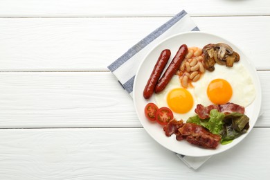 Photo of Delicious breakfast with sunny side up eggs on white wooden table, top view. Space for text