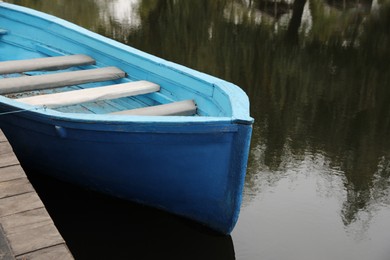 Photo of Light blue wooden boat on lake near pier