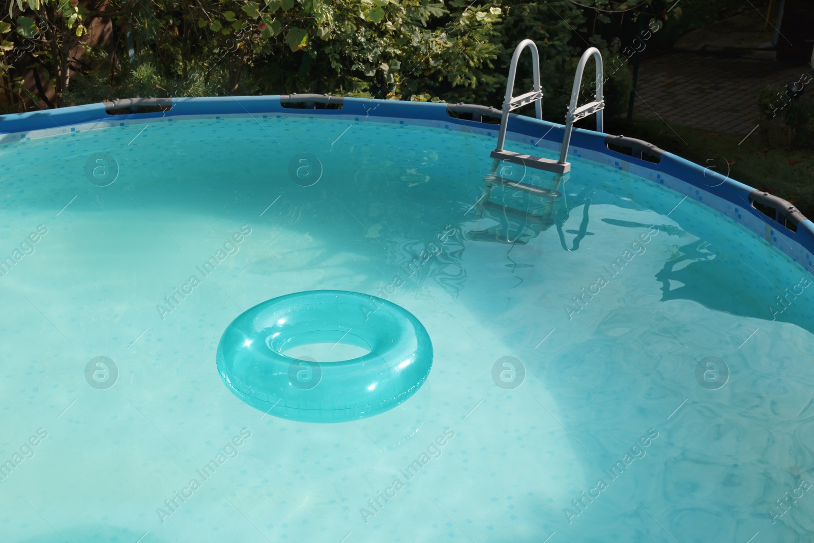 Photo of Inflatable ring floating on water in above ground swimming pool outdoors