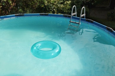 Photo of Inflatable ring floating on water in above ground swimming pool outdoors