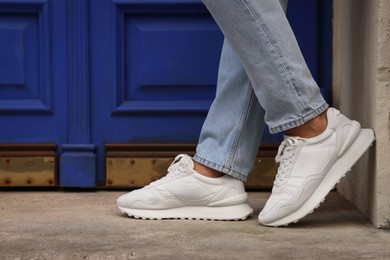 Photo of Man wearing pair of stylish sneakers outdoors, closeup