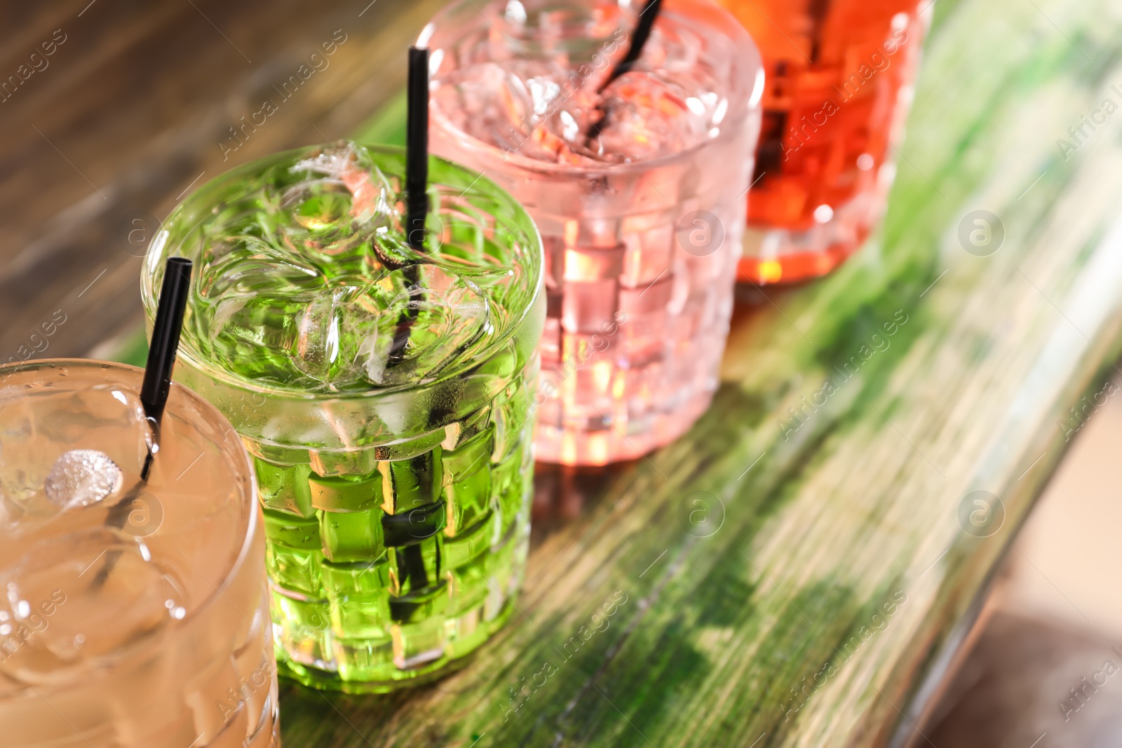 Photo of Glasses of delicious cocktails with ice on table, closeup