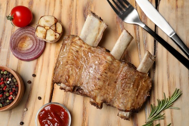 Photo of Flat lay composition with roasted ribs on wooden background. Tasty meat