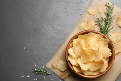 Flat lay composition with potato chips on grey table. Space for text