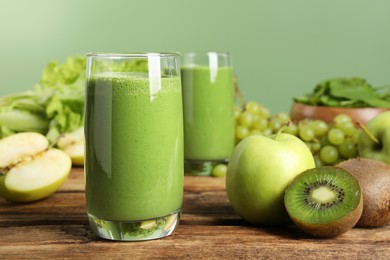 Photo of Green smoothie and fresh ingredients on wooden table