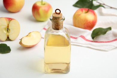 Photo of Natural apple vinegar and fresh fruits on white table
