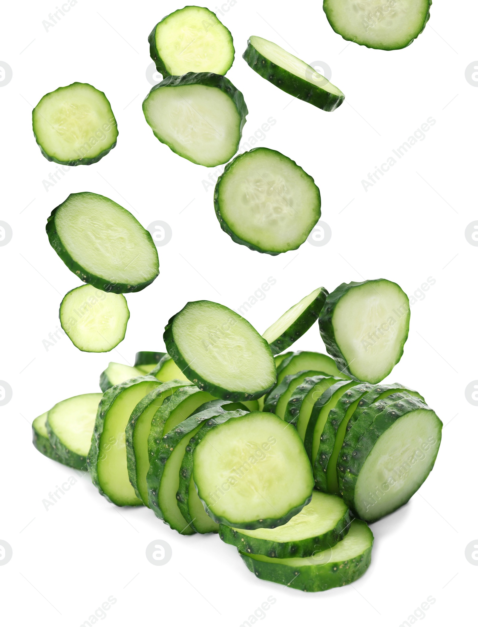 Image of Slices of fresh green cucumbers falling on white background