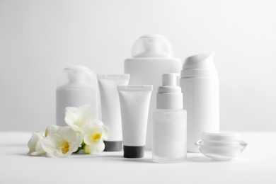 Photo of Cosmetic products on table against light background