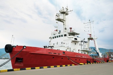 Photo of Modern red and white ship moored in sea port