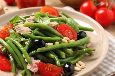 Photo of Plate of tasty salad with green beans on table, closeup