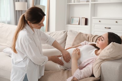 Doula taking care of pregnant woman at home. Preparation for child birth