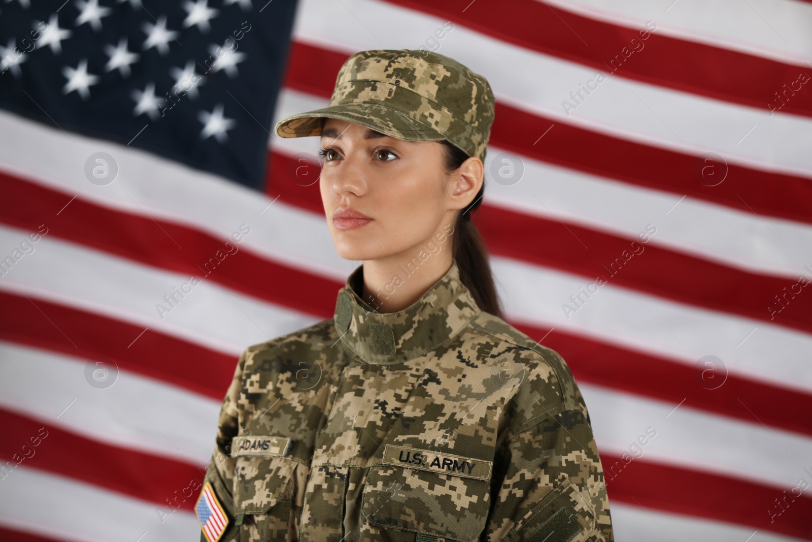 Photo of Female American soldier with flag of USA on background. Military service