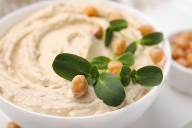 Bowl of delicious hummus with chickpeas, closeup