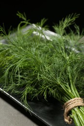Photo of Bunch of fresh dill on grey table, closeup
