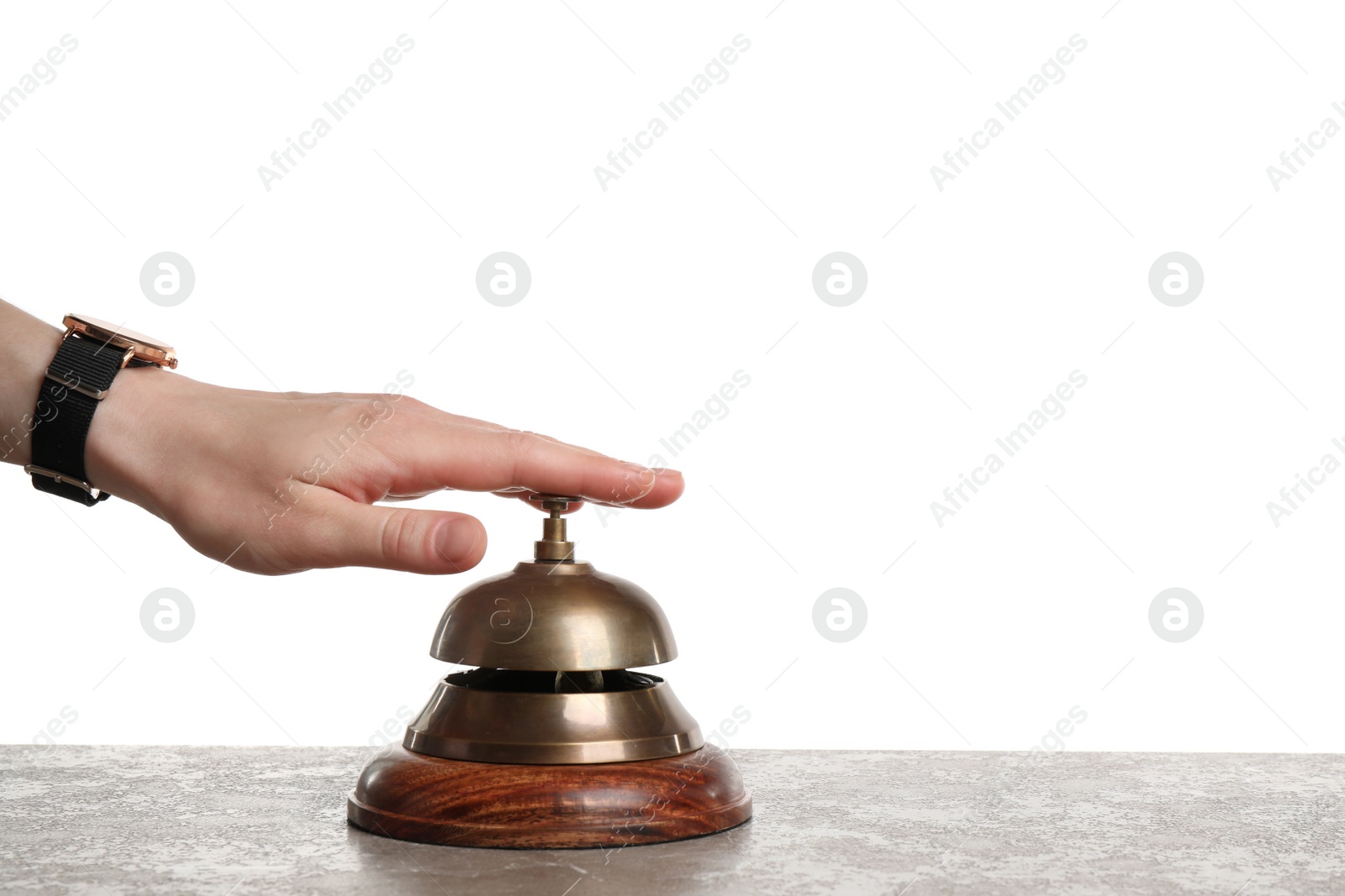 Photo of Woman ringing hotel service bell at grey stone table