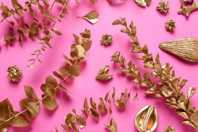Photo of Flat lay composition with golden dried flowers and eucalyptus branches on pink background