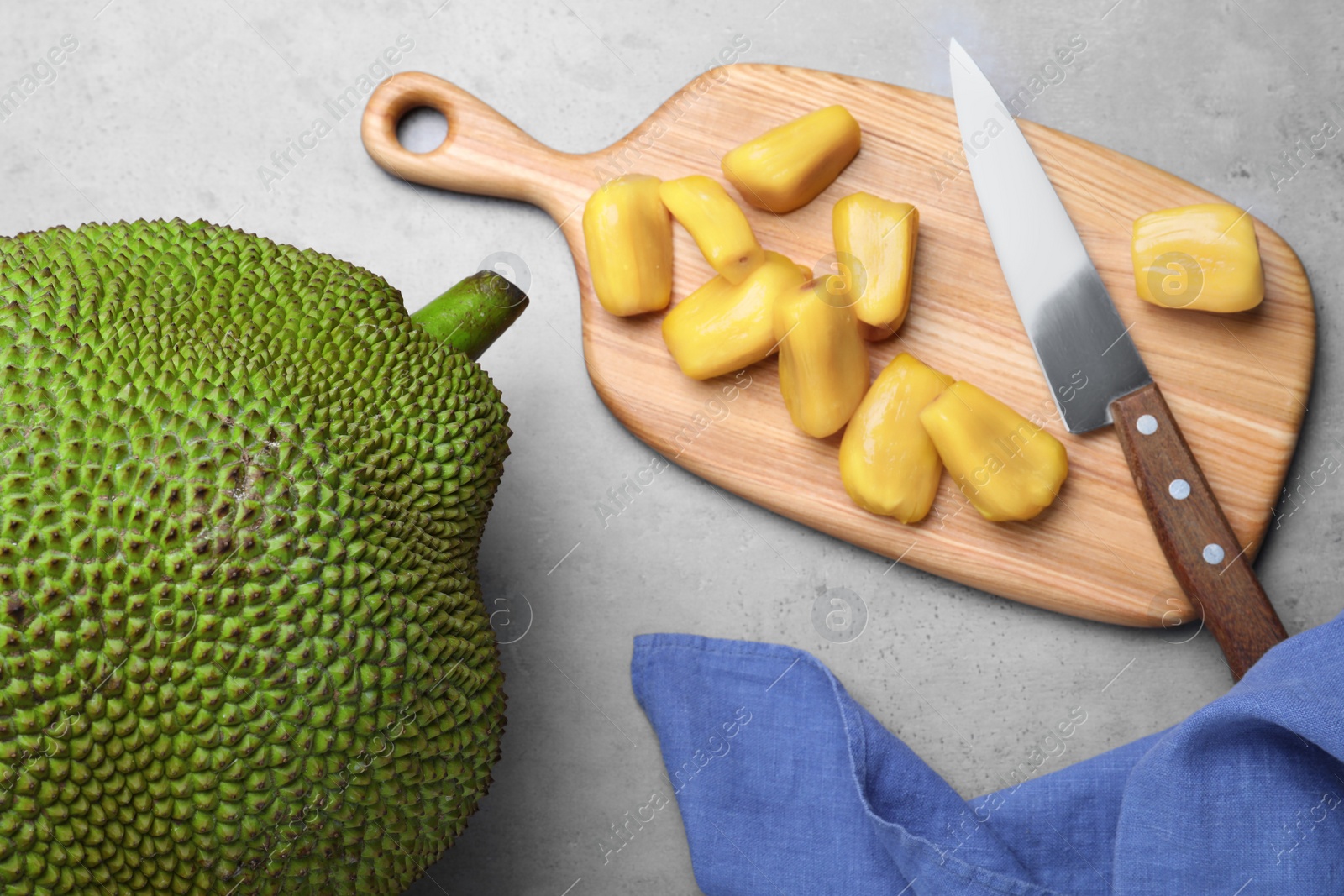 Photo of Delicious exotic jackfruit and bulbs on light grey table, flat lay