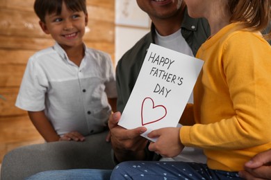 Photo of Little children greeting their dad with Father's Day at home, closeup