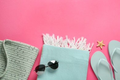 Flat lay composition with different beach objects on pink background, space for text