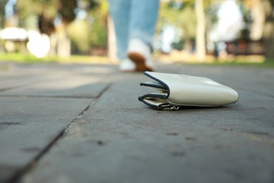 Woman lost her purse on pavement outdoors, selective focus. Space for text