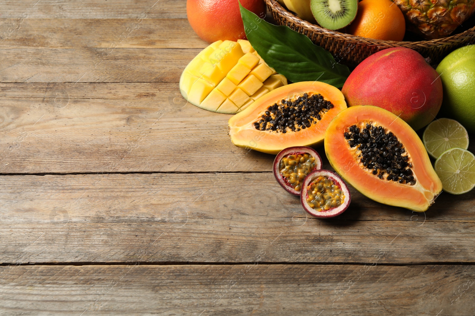 Photo of Fresh ripe papaya and other fruits on wooden table, above view. Space for text