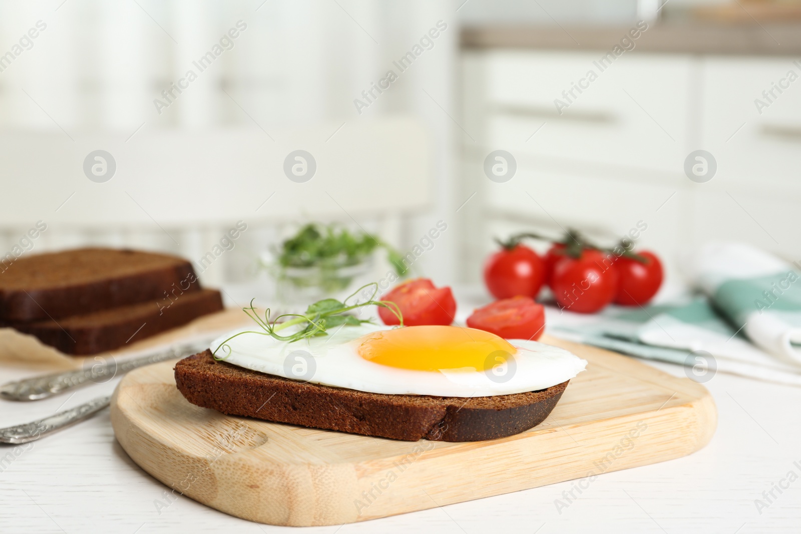 Photo of Tasty fried chicken egg with sprouts and rye bread on wooden board