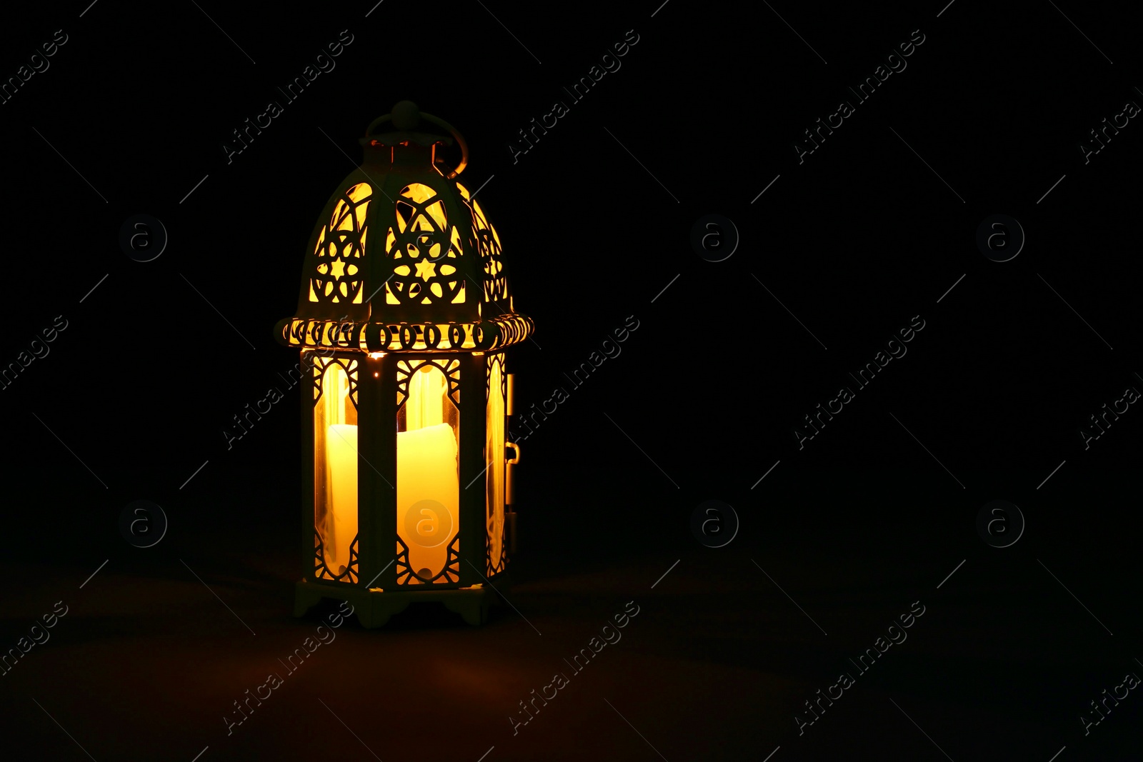 Photo of Decorative Arabic lantern on table against dark background. Space for text