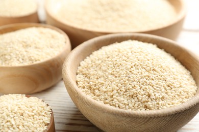Photo of White sesame seeds on wooden table, closeup